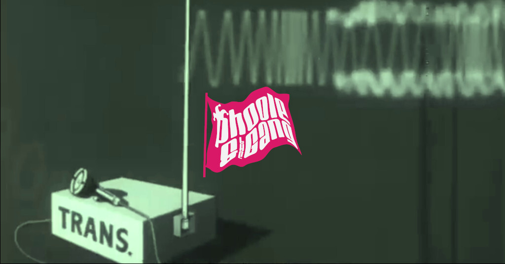 A frame from the 1944 US War Department film, BASIC PRINCIPLES OF FREQUENCY MODULATION, illustrating a frequency-modulation (FM) radio signal transmitter, labeled “TRANS.”, transmitting a signal. The Phoole and the Gang fuchsia flag logo is included.