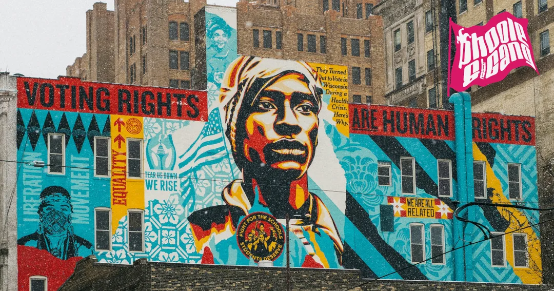 A photograph by Tom Barrett of Shepard Fairey’s VOTING RIGHTS ARE HUMAN RIGHTS mural, on the north face of Milwaukee’s Coby-Abbot building on North Milwaukee Street downtown. The mural features a portrait of an African-American man looking upward as its central figure, based on a Civil-Rights-era photograph by Steve Schapiro. Art by Milwaukee artists Tom Jones, Dyani White Hawk, Tyanna Buie, Niki Johnson and Claudio Martinez surround the central figure. 